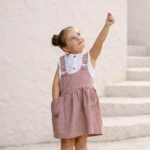 alt="Niña feliz con pichi Natura teja de Kannela"