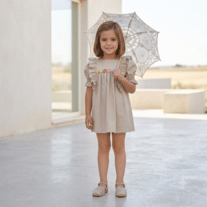 alt="Niña con sombrilla de ganchillo y vestido Flores de Kannela"